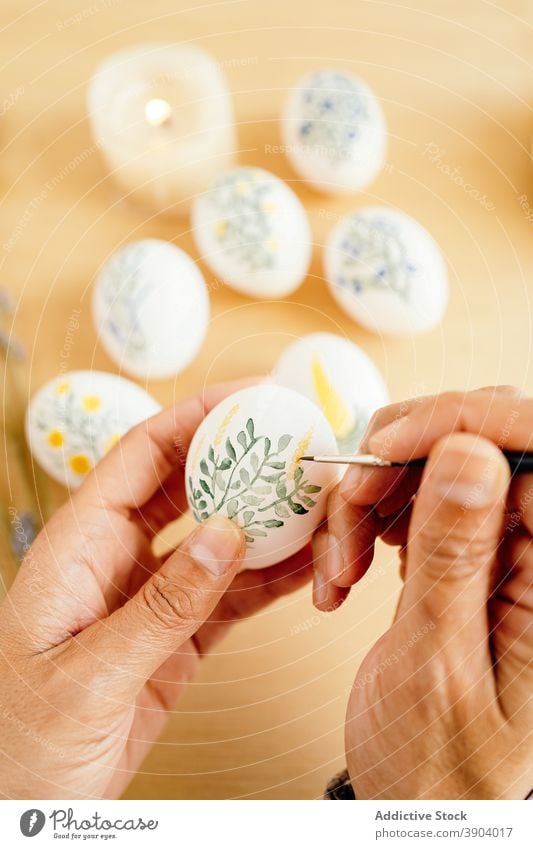 Crop artist painting eggs for Easter painter easter religious holiday prepare artwork flower spring aquarelle food tradition table religion decor color set