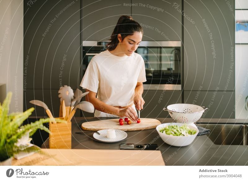 Woman cutting tomatoes in kitchen woman cook lunch vegetable cherry ripe cutting board female knife food culinary nutrition healthy vitamin vegetarian