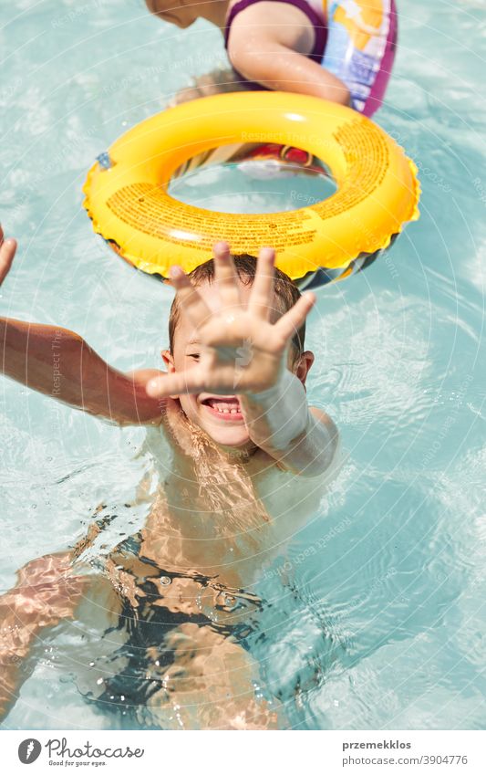 Happy boy playing in a pool authentic backyard childhood children family fun garden happiness happy joy kid laughing lifestyle playful real recreation relaxing