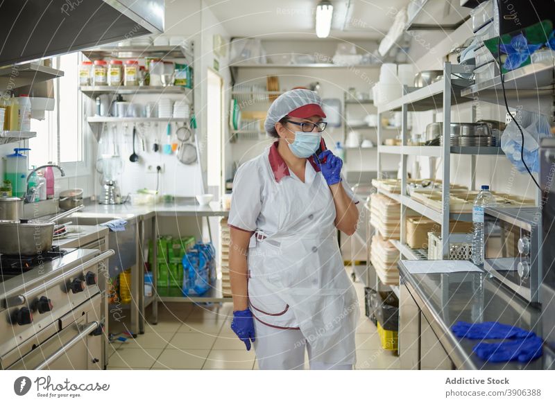 Hospital cook talking on phone in kitchen hospital coronavirus mask protect smartphone work woman pandemic covid 19 covid19 epidemic female job speak