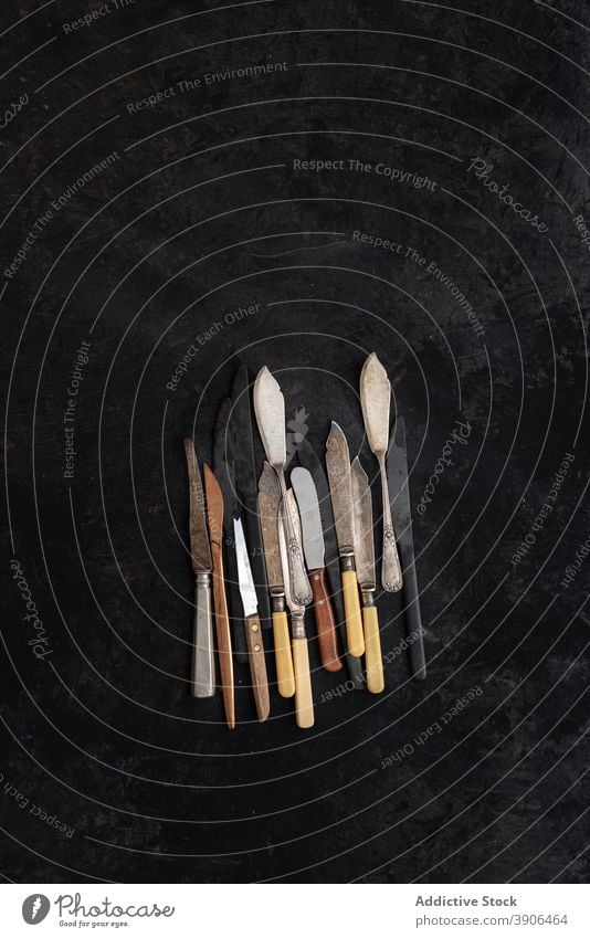 Various old knives on black table knife collection retro old fashioned vintage silverware set assorted utensil various metal nostalgia rustic simple cutlery