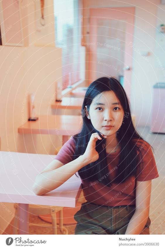 Young asian teen cute millennial girl looking at the camera and sitting in pastel pink cafe, lifestyle concept one loneliness rest calm woman alone leisure