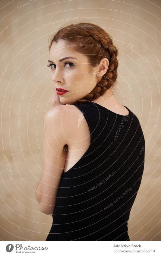 Woman with braids in studio looking at camera redhead hairstyle woman appearance charming trendy red hair female red lips model personality individuality