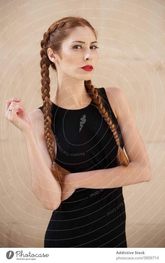 Woman with braids in studio looking at camera redhead hairstyle woman appearance charming trendy red hair female red lips model personality individuality