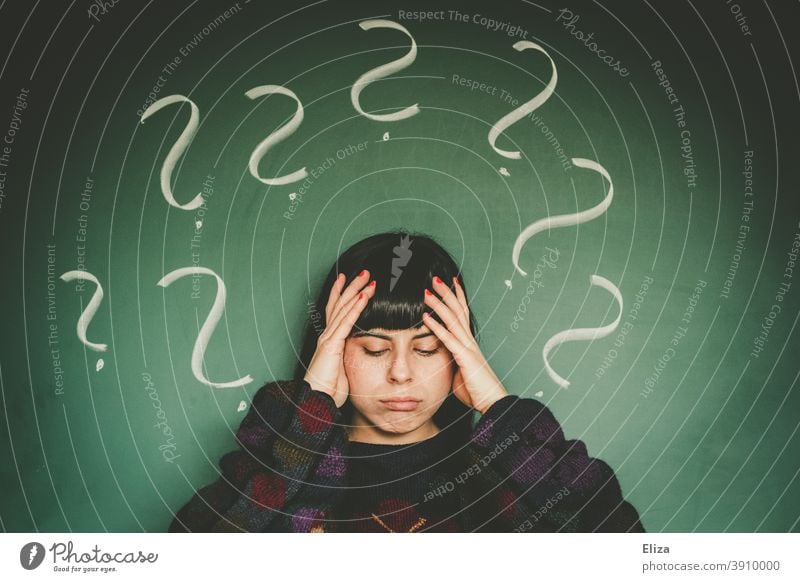 Young woman with many question marks. Indecision and helplessness. Question mark Woman indecisiveness Disorientated Perplexed disorientation Ask Concern