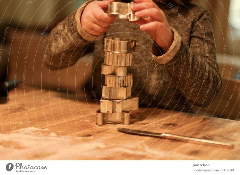 A child stacks cookie cutters on flour dusted table.pre christmas, baking, tradition Cookie Baking outdo sb. Christmas Hand Tradition Christmas & Advent