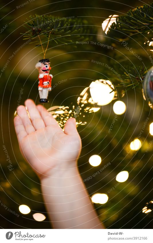 christmas figure hangs on the christmas tree and is examined by the child Christmas tree Christmas & Advent Toddler Appraise Observe Cute Christmassy