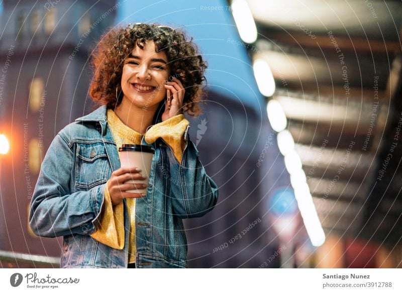 Happy Young Woman Using Phone copyspace standing using phone phone call calling cup of coffee front view portrait girl woman young 20s curly hair female street