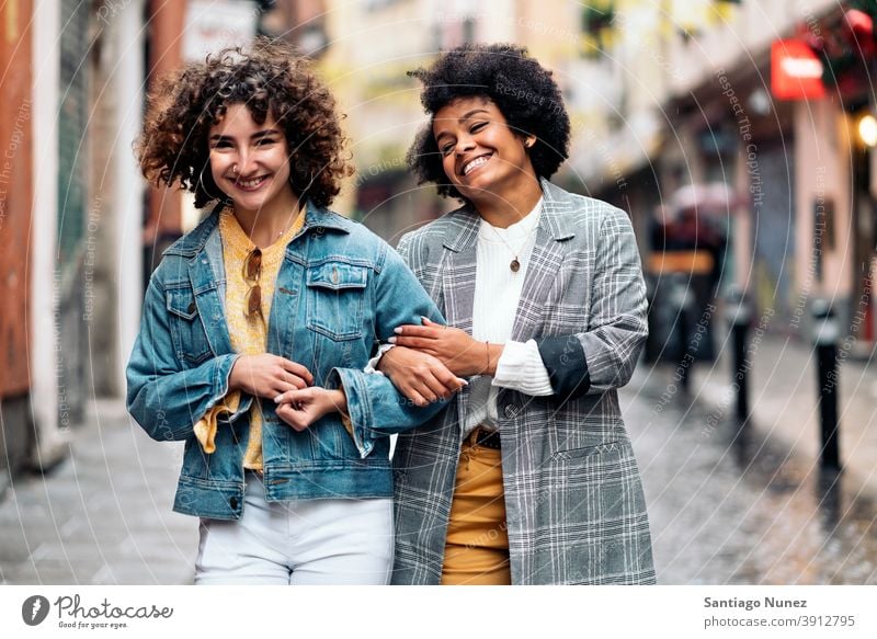 Friends Walking in Rainy Day looking at camera walking street friends women multi-ethnic afro girl caucasian portrait having fun front view friendship rainy day