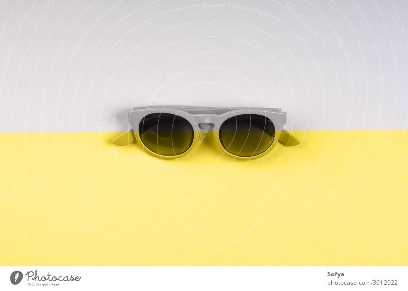 Illuminating yellow and gray sunglasses backdrop duotone illuminating color grey fashion split year ultimate background modern summer trendy object minimal