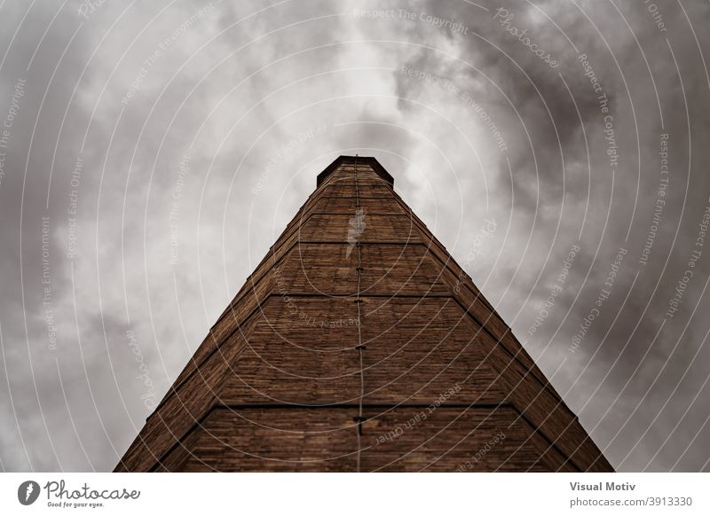 Smokestack of an old factory under a stormy sky smokestack afternoon architectonic architectural cloudy architecture brick built color exterior industrial