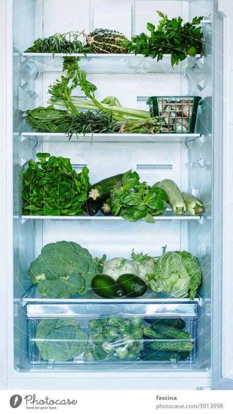 Green vegetables and greens in open refrigerator full fridge food fresh diet freezer kitchen cold domestic freshness home healthy lifestyle natural nutrition