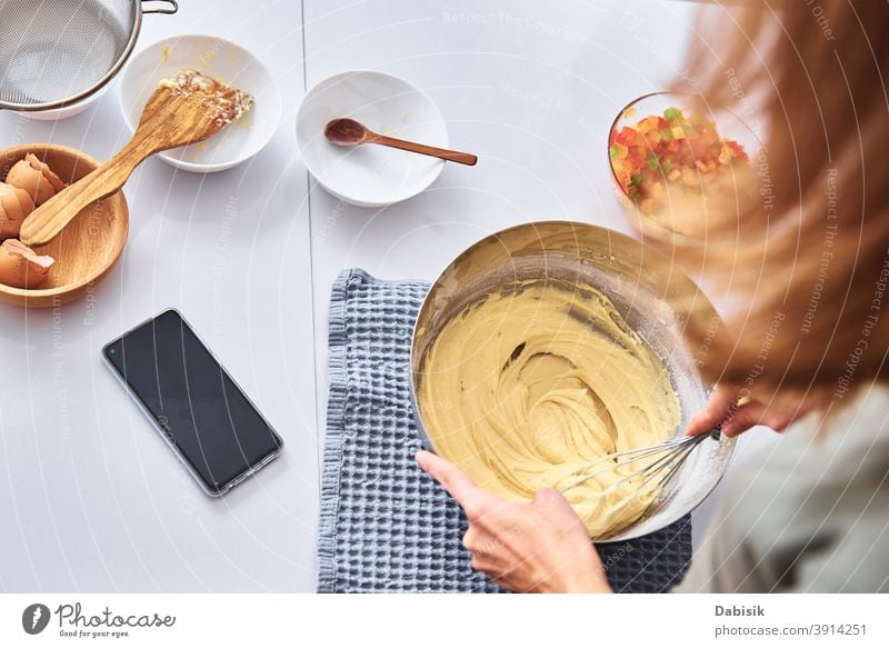 Woman in kitchen cooking a cake. Hands beat the dough with mixer woman recipe ingredients food person home female caucasian diet meal lifestyle prepare people