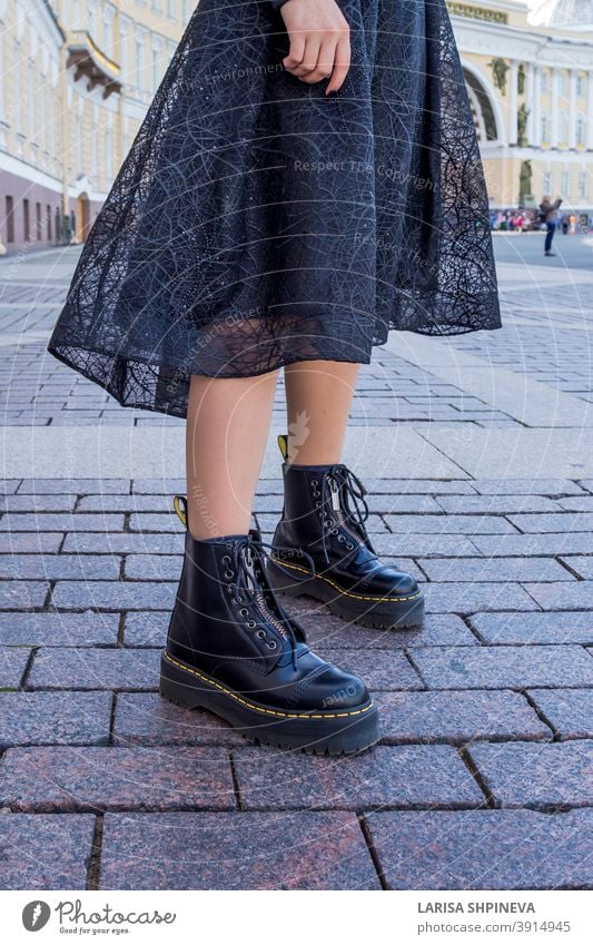 Part of clothing element of fashionable woman's wardrobe is chic black dress and boots. girl lady outdoor portrait attractive street beautiful young urban