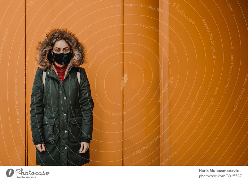 woman with face mask standing against orange city wall adult attractive beautiful beauty blonde bus station caucasian confident coronavirus covid-19 croatia