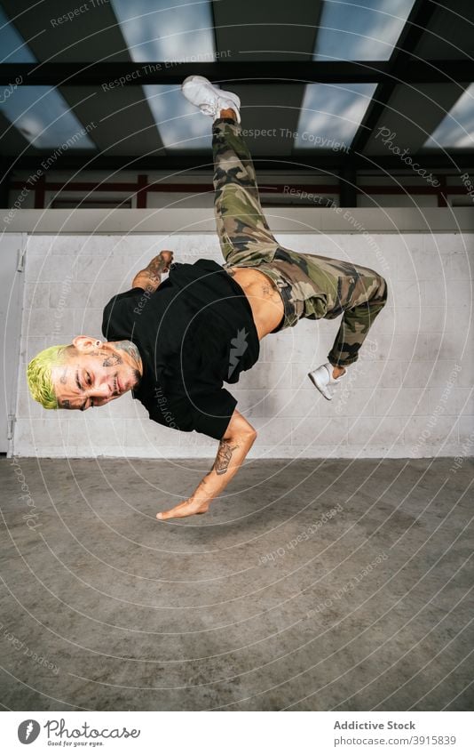 Male break dancer performing handstand man trick acrobatic energy move style active young male activity lifestyle skill modern practice balance talent agile