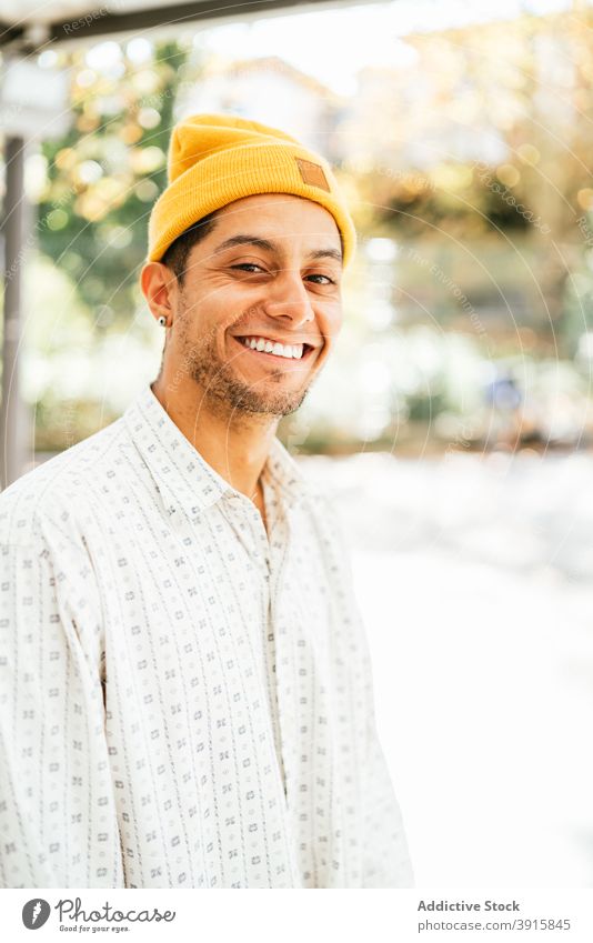 Cheerful hipster man looking at camera cheerful smile informal trendy style hat positive young male beard unshaven happy optimist personality guy charismatic