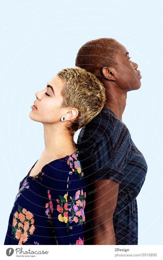 Two diverse women standing back to back in studio female portrait woman young 2 girlfriend together african american difference friendship contrast eyes closed