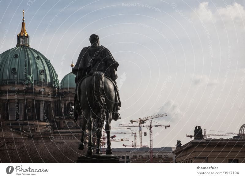 Equestrian statue in front of the cathedral and cranes in Berlin Dome old guard farsightedness outlook Sky Clouds Vantage point Contrast modern History of the