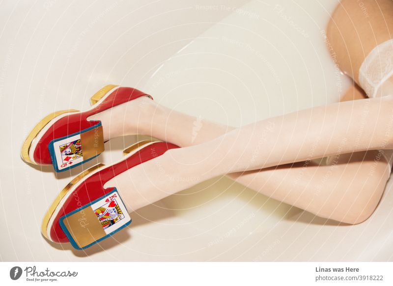 These shoes were definitely not made for walking in the fields. Why not try milky bath instead. A photo of stylish, golden, red, avant-garde women shoes in a milk bath. Oh, and you can see long and gorgeous legs in it as well.