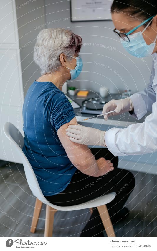 Senior woman being vaccinated against coronavirus vaccination covid-19 patient elderly injection immunization doctor syringe senior medical healthcare arm older