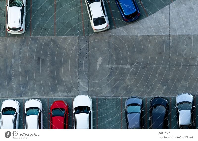 Top view concrete car parking lot. Aerial view of car parked at car parking area of apartment. Outdoor parking space with empty slot. One way traffic sign on road. Above view outside car parking lot.