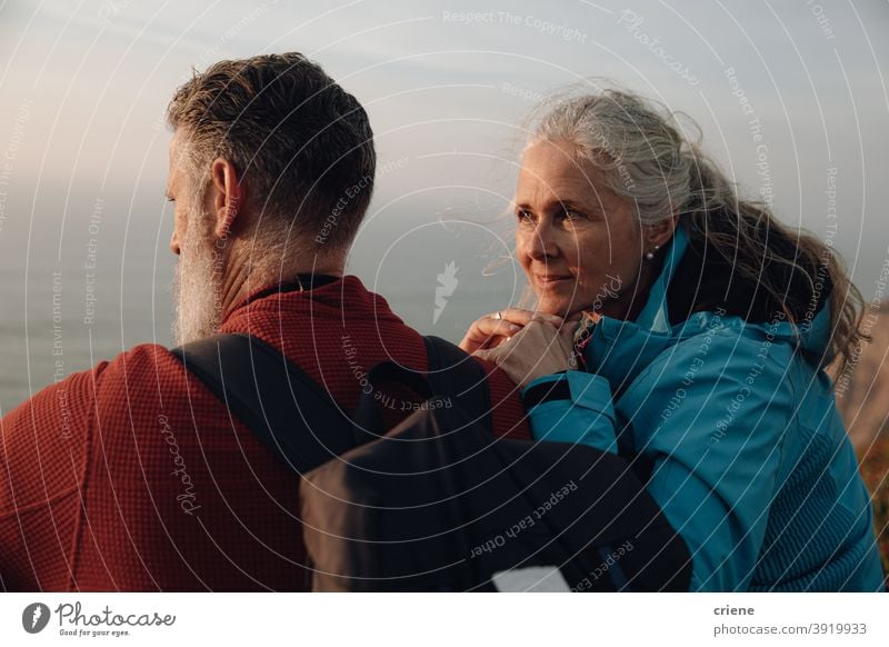 caucasian senior couple sitting on cliff enjoying sunset together love woman people happy two old family romance outdoors elderly happiness portrait smiling