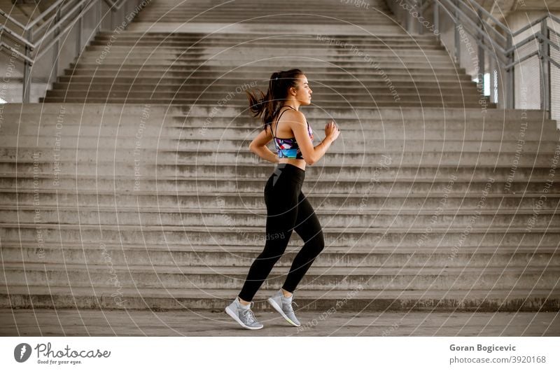 Young woman running in the urban environment stairs exercise training fitness female runner athlete workout city young lifestyle healthy person activity one