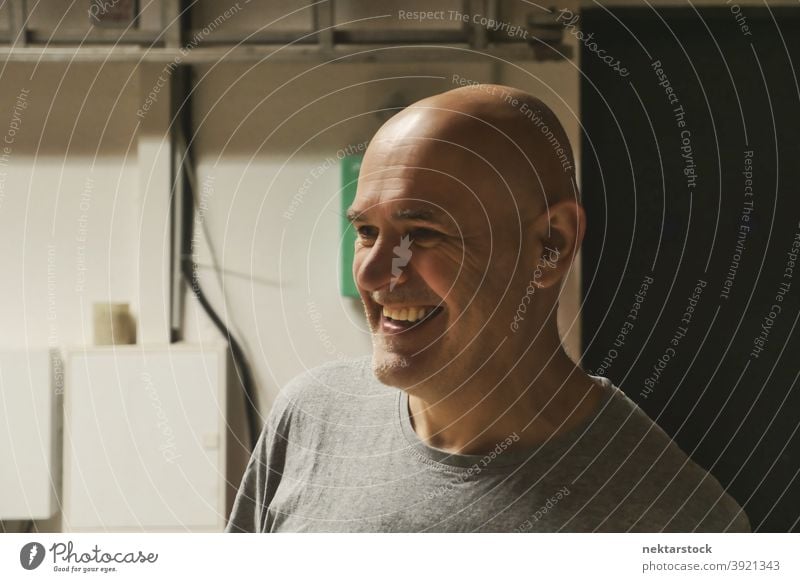 Bald Headed Man Smiling in Garage Background man bald caucasian worker workshop diy no hair 1 person garage background handiwork industrial machine shop