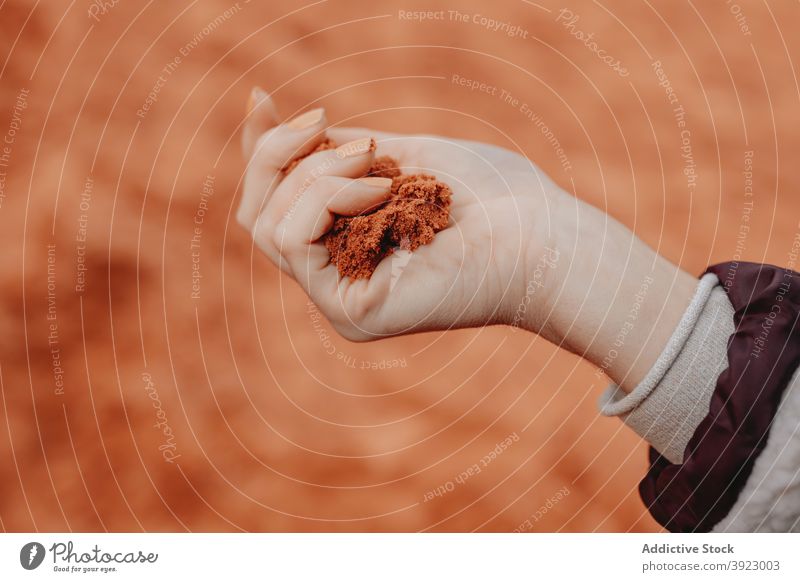 Crop person with handful of sand in desert dry soil arid valley barren location wadi rum jordan nature red color dried natural stand terrain geology drought