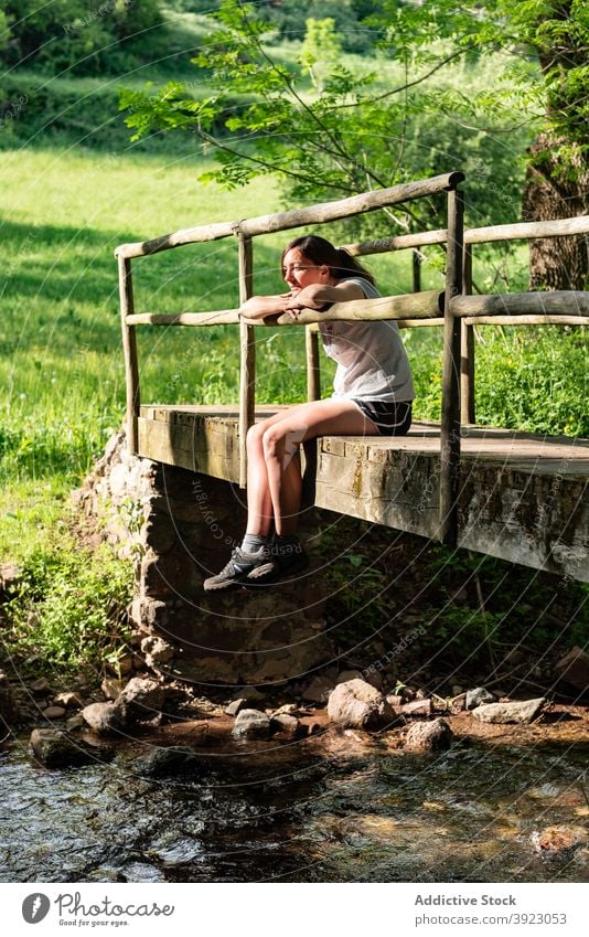 Woman relaxing on bridge in forest woman woods summer river enjoy carefree nature female peaceful tree sit freedom water creek brook old tranquil calm