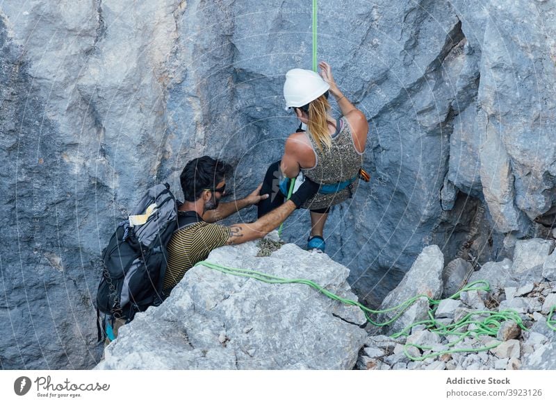 Mountaineers preparing for ascending rocky slope climber mountaineer couple active prepare safety rope harness gear nature extreme sport activity confident