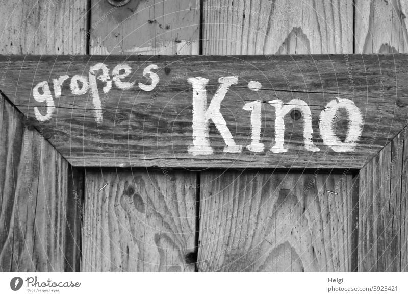 big cinema - white writing on the wall on an old wooden board Large Cinema Word Wood Wooden wall Wooden board Old White Gray Black Wood grain Letters (alphabet)