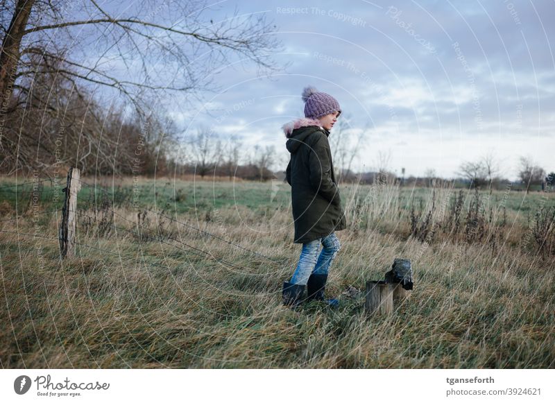 Child in front of an old pasture fence and bench Girl Human being 1 Pasture fence Barbed wire Barbed wire fence Catkin Exterior shot Meadow Barrier Colour photo