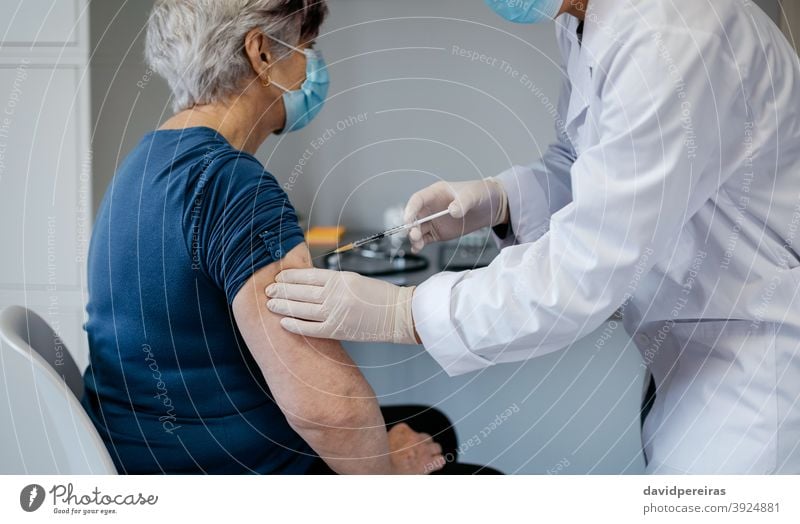 Senior woman being vaccinated against coronavirus vaccine covid-19 patient older injecting immunization doctor syringe senior medicine injection health medical