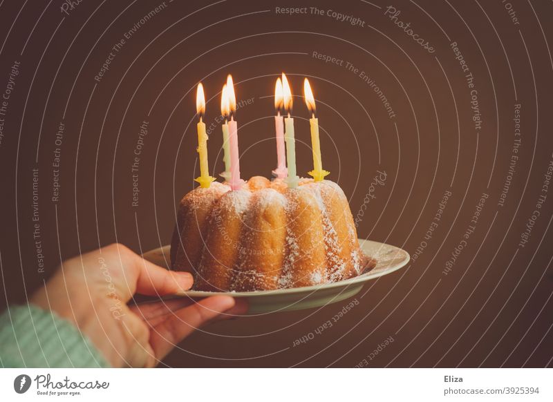 Hand holding a birthday cake with burning candles Birthday birthday candles Cake Happy Birthday Birthday celebration guglhupf Feasts & Celebrations