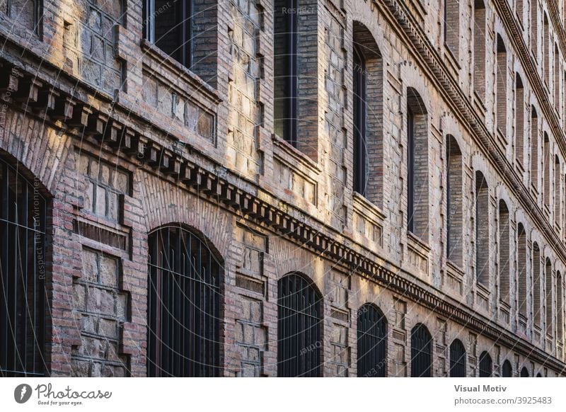 Rows of windows of an old restored industrial factory architecture building facade exterior structure construction urban metropolitan edifice rows frontage