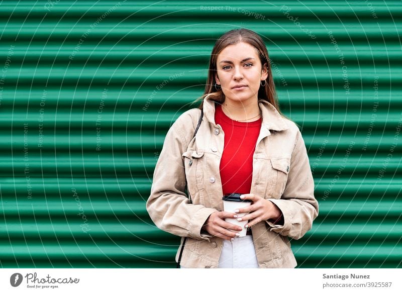 Pretty Young Girl Portrait portrait looking at camera cup of coffee green background standing pretty woman girl young female outside outdoors front view posing