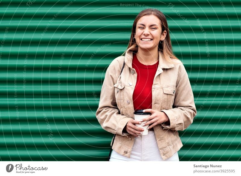 Happy Young Girl Portrait portrait looking at camera cup of coffee green background standing pretty woman girl young female outside outdoors front view posing