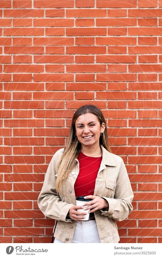 Young Girl Smiling Portrait portrait looking at camera cup of coffee wall standing pretty woman girl young female outside outdoors front view posing one person