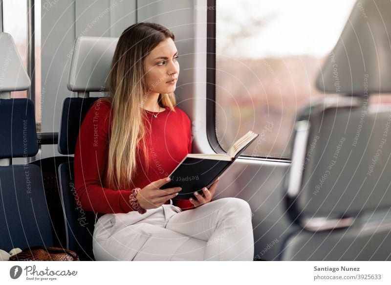 Girl Reading Book in Train book reading focused train traveling girl portrait young 20s front view blonde pretty caucasian looking woman female traveler