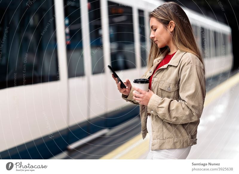 Blonde Girl Waiting For Train side view woman caucasian train motion portrait using phone typing looking background standing female indoors metro transport