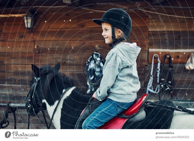 Little smiling girl learning horseback riding kid ride practice school cute country pretty rural ranch lesson rider happiness countryside active equestrian