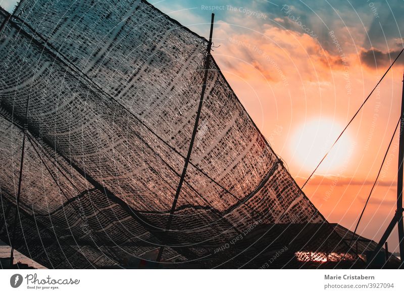 Fish nets against the sunset sky, showing the daily life and culture in the fishing village of Ben Tre, Mekong Delta Vietnam outdoor travel photography holidays