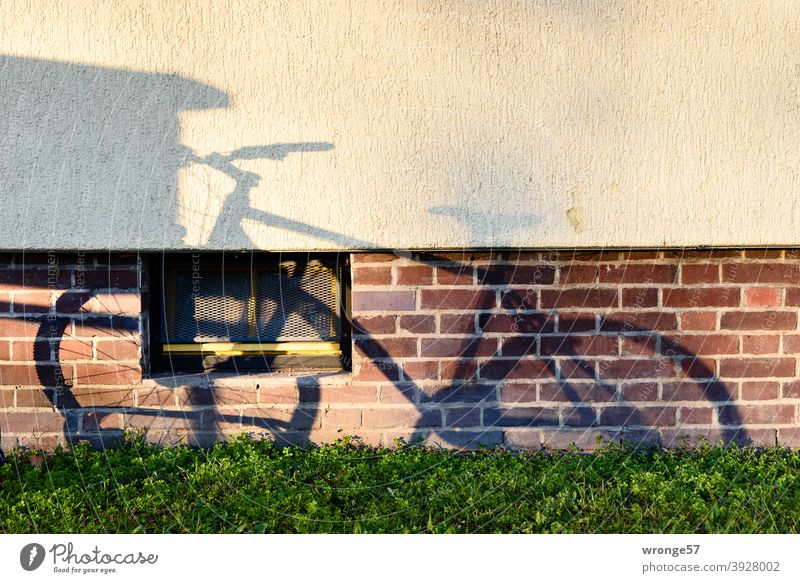 Shadow image of a bicycle standing in a bicycle stand on the wall of an apartment building Shadow play shadow cast Bicycle Mountain bike mtb Wall (building)