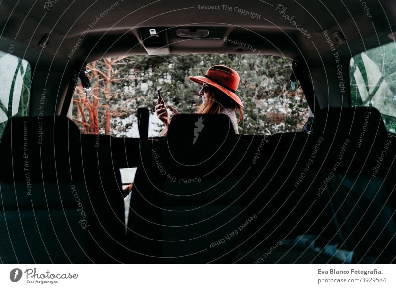 back view from inside a car of young woman outdoors wearing stylish hat. Winter season. snowy mountain background winter enjoy nature leisure green weather