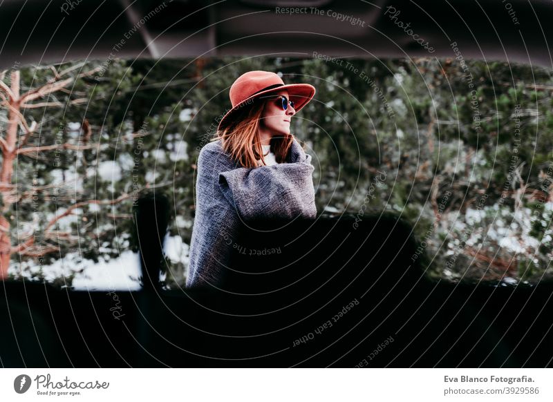 back view from inside a car of young woman outdoors wearing stylish hat. Winter season. snowy mountain background winter enjoy nature leisure green weather