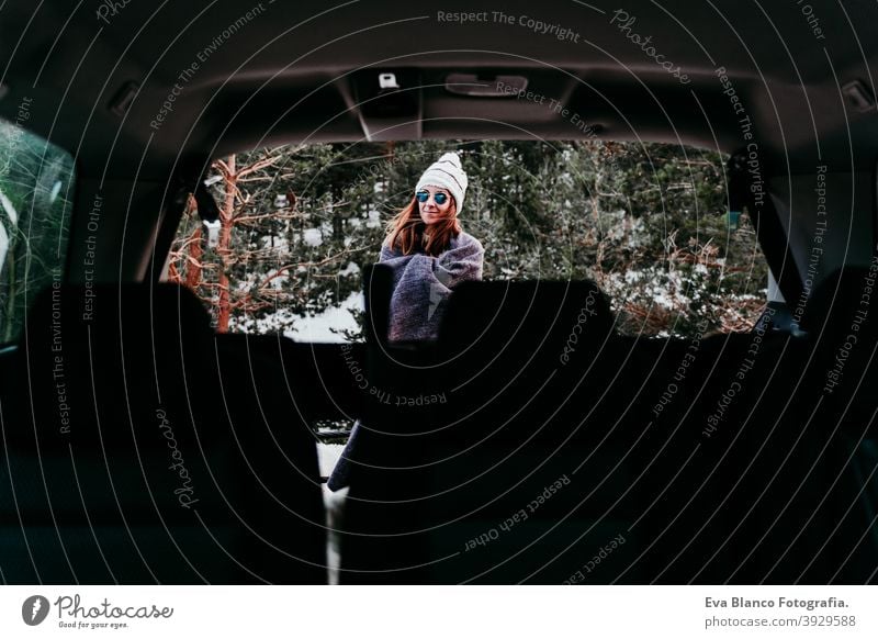 back view from inside a car of young woman outdoors wearing stylish hat. Winter season. snowy mountain background winter enjoy nature leisure green weather