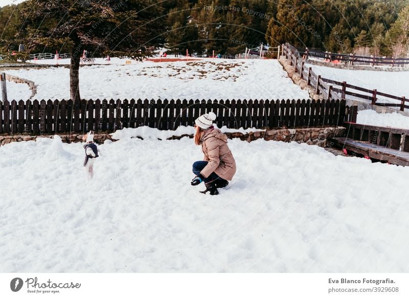 woman and cute jack russell dog enjoying outdoors at the mountain with snow. winter season travel lifestyle wanderlust traveling fun cold tress forest hug