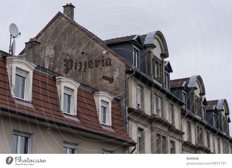 Text Pizzeria in squiggly writing and arrow down to the entrance on an old house gable pizzeria house gables House (Residential Structure) Old Arrow Direction